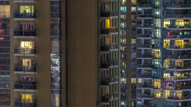 Windows çok katlı binanın içinde aydınlatma ve insanlar timelapse içinde hareketli çelik ve cam. Dubai Yat Limanı içinde modern konut gökdelenler hava görünümünü. Yakınlaştır
