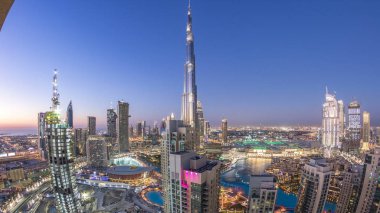 Dubai gece geçiş timelapse, çeşmeler ile ışıklı lüks modern binalar, Birleşik Arap Emirlikleri fütüristik cityscape downtown gün. Güneş battıktan sonra gökdelen üzerinden hava üstten görünüm