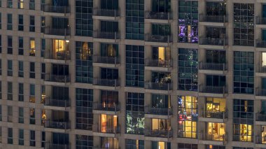 Windows çok katlı binanın içinde aydınlatma ve insanlar timelapse içinde hareketli çelik ve cam. Dubai merkezinde modern konut gökdelenlerin havadan görünümü. Sağa çevir