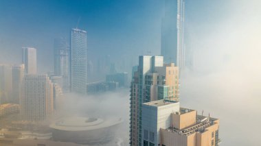 Downtown Dubai timelapse Sisli sabah. Şehir gökdelenler fütüristik görünümünü sis kaplı. Çatı gündoğumu sırasında modern kuleli havadan görünümden. Dubai, Birleşik Arap Emirlikleri