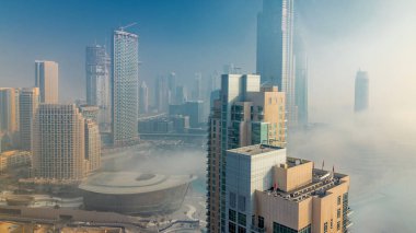 Downtown Dubai timelapse Sisli sabah. Şehir gökdelenler fütüristik görünümünü sis kaplı. Çatı gündoğumu sırasında modern kuleli havadan görünümden. Dubai, Birleşik Arap Emirlikleri