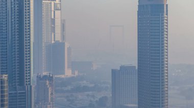 Downtown Dubai timelapse Sisli sabah. Şehir gökdelenler fütüristik görünümünü sis kaplı. Çatı gündoğumu sırasında modern kuleli havadan görünümden. Dubai, Birleşik Arap Emirlikleri