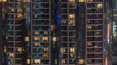 Windows çok katlı binanın içinde aydınlatma ve insanlar timelapse içinde hareketli çelik ve cam. Dubai merkezinde modern konut gökdelenlerin havadan görünümü. Vınlamak dışarı
