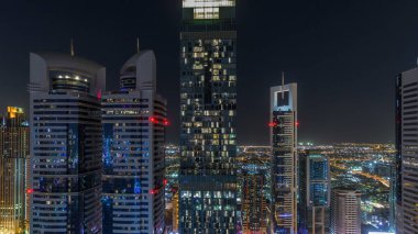 Sheikh Zayed Road ve DIFC gece timelapse Dubai, BAE binaların görünümünü manzarası. Yukarıdan finans merkezi hava görünümünde ışıklandırılmış gökdelenler