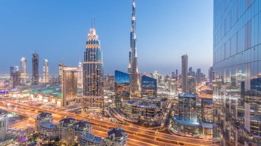 Gece geçiş timelapse en yüksek binası ve Sheikh Zayed karayolu trafik, Birleşik Arap Emirlikleri Dubai şehir manzarası günler. Güneş battıktan sonra modern kuleli gökdelenin çatı üzerinden havadan görünümü