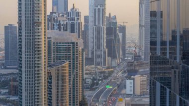 Üst Dubai, Suudi Arabistan, Dubai Downtown Timelapse modern kuleleri akşam gökdelenler görüntüleyin. Gün batımından önce business bay yakınındaki yolda trafik