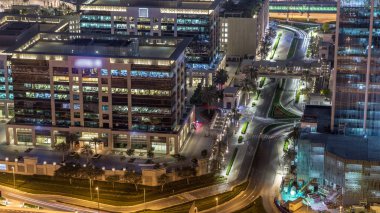 Dubai şehir manzarası gece timelapse ve karayolu trafik, Birleşik Arap Emirlikleri. Işıklı modern binalar ile gökdelenin çatı üzerinden havadan görünümü