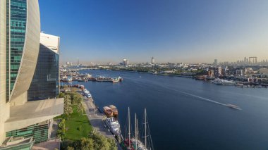 Dubai creek manzara timelapse tekneler ve bağlantı noktası, sakin su ve gün batımı sırasında arka planda modern binalar gemi ile. Yukarıdan hava üstten görünüm
