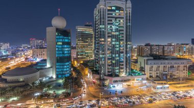Dubai Creek alan modern binalar ve yoğun trafik sokak gece geçiş timelapse çevrili. Işıklandırılmış gökdelenler ile yukarıdan hava üstten görünüm