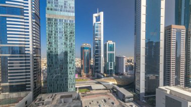 Manzarası, Dubai, Birleşik Arap Emirlikleri bütün gün timelapse Sheikh Zayed Road ve DIFC binaların görüntüleyin. Mali içinde gökdelenler yukarıdan hava görünümünü merkezi. Çok hızlı hareket gölgeler