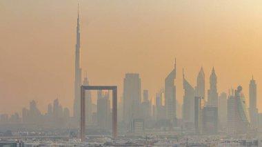 Dubai creek manzara timelapse tekneler ve yatlar ve gün batımı sırasında arka planda şehir gökdelenler ile modern binalar ile. Yukarıdan hava üstten görünüm
