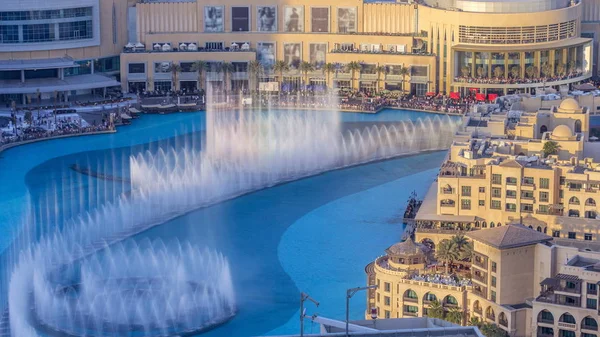 Evening aerial view Dancing fountains downtown and in a man-made lake timelapse during sunset in Dubai, UAE. The Dubai Dancing fountains are world\'s largest fountains with height 150 m.