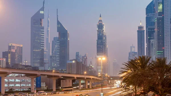Kavşak ve köprü gece geçiş timelapse gökdelenler gün çevrili Sheikh Zayed Road üzerinde trafik. Yukarıdan akşam itibariyle Birleşik Arap Emirlikleri Dubai oteli göster