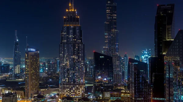 Dubai downtown skyline night timelapse with tallest building and Sheikh Zayed road traffic, UAE. Aerial view from rooftop of skyscraper with illuminated modern towers