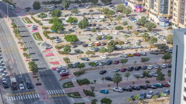 Park yerinde timelapse sarı, beyaz, siyah, gri, gümüş, mavi, diğeri gibi renkli araç çeşitleri ile gökdelenin çatı üzerinden en iyi görünümü. Arabalar değişiklikleri, gölgeler hızlı taşır. Dubai, Birleşik Arap Emirlikleri