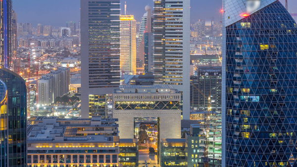 Skyline view of the buildings of Sheikh Zayed Road and DIFC day to night transition timelapse in Dubai, UAE. Skyscrapers in financial centre aerial view from above after sunset