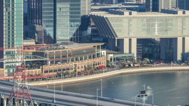 Gün batımından önce Abu Dabi şehir merkezinden gökdelenlerin gölgeleriyle birlikte. Köprü ve trafik yolda.