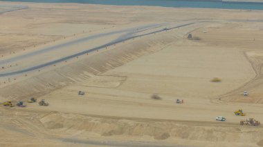 Yol yapımı sırasında toprak sıkıştırıcı ve buldozer zaman ayarlı çalışır. Yukarıdan hava görüntüsü. Abu Dabi, BAE
