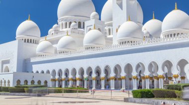 Birleşik Arap Emirlikleri 'nin başkenti Abu Dabi' deki Şeyh Zayed Büyük Camii zaman çizelgesi. Çeşmeli, kubbeli ve minareli yan manzara. Güneşli bir günde mavi gökyüzü