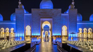 Şeyh Zayed 'in Ulu Camii gece vakti aydınlandı. Abu Dabi, BAE. Çeşmeli ön manzara. Dünyanın en büyük üçüncü camii.