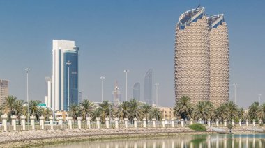 Abu Dhabi, Birleşik Arap Emirlikleri - Mart 2018 yaklaşık: Al Bahr ile gökdelenler manzarası görmek Abu Dabi timelapse kuleleri. Su ve avuç içi sokakta üzerine düşünceler. Birleşik Arap Emirlikleri