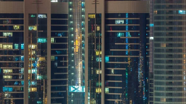 窗户的多层摩天大楼的玻璃和钢铁办公照明和人在 Timelapse 公寓里闪烁着光芒 阿布扎比 阿联酋 — 图库照片