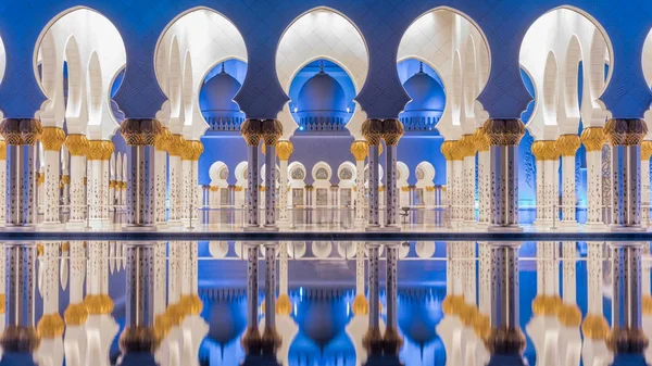 Büyük Sheik Zayed Camisi gece timelapse, Abu Dhabi, Birleşik Arap Emirlikleri aydınlatılmış. Yan görünümü yansıması su havuzu ile. Dünyanın 3 büyük Camisi