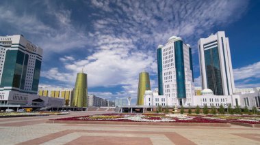 Astana, Kazakistan Cumhuriyeti timelapse hyperlapse devlet Senato binası. Flowerbed ön planda. Nurzhol Bulvarı'arka plan. Mavi bulutlu gökyüzü yaz gün