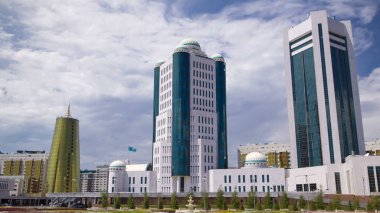 Astana, Kazakistan Cumhuriyeti timelapse hyperlapse devlet Senato binası. Flowerbed ön planda. Nurzhol Bulvarı'arka plan. Mavi bulutlu gökyüzü yaz gün