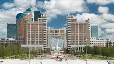 Yeni iş bölgesinde timelapse trafik yol ve park ile Kazakistan Astana'nın başkenti Khan Shatyr merdivenlerde çeşmeden ile.