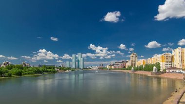 Yeşil nehir timelapse hyperlapse Astana içinde konut kompleksi modern kuleleri ile. Park ve setin yanında. 4k
