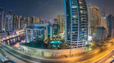 Dubai Yat Limanı tekneleri su ve arabalar road, Dubai, Birleşik Arap Emirlikleri ışık yollar ile üstten görünüm, gece timelapse. Çatıdan balıkgözü görüntülemek