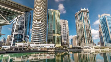 Gökdelenler waterfront adlı Hyperlapse görünümü. Jumeirah Gölü Towers konut binalarında su timelapse Dubai, BAE yansıtılır. Jlt 79 kuleleri 3 yapay göl ve park ile oluşan büyük bir gelişmedir. Mavi bulut ile göster