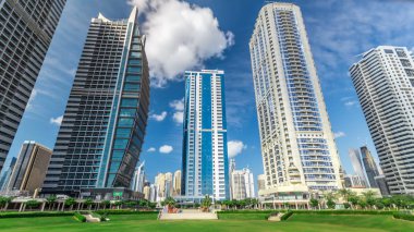 Dubai, Birleşik Arap Emirlikleri Jumeirah Gölü Towers timelapse konut binalarda. Jlt 79 kuleleri 3 yapay göl ve park ile oluşan büyük bir gelişmedir. Park mavi bulutlu gökyüzü ile göster