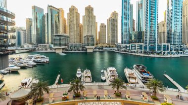 Dubai Yat Limanı ile modern binalar ve geleneksel tekne timelapse. Günbatımı zaman modern kulenin üstten görünüm