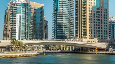 Dubai Yat Limanı modern kuleleri ve köprü kayan yatların ve Promenade timelapse, Birleşik Arap Emirlikleri deniz araçları ile güzel bir gün görünümü. Dubai Yat Limanı Dubai ve bir yapay kanal şehir içinde bir ilçedir. Mavi bulutlu gökyüzü