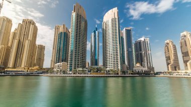 Dubai Yat Limanı modern kuleleri kayan yatların ve Promenade timelapse, Birleşik Arap Emirlikleri deniz araçları ile güzel bir gün görünümü. Dubai Yat Limanı Dubai ve bir yapay kanal şehir içinde bir ilçedir. Mavi bulutlu gökyüzü