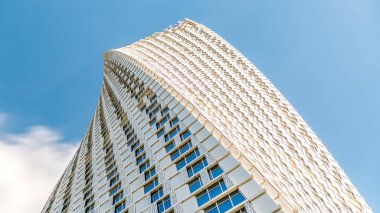 Dubai, Birleşik Arap Emirlikleri - 03 Ocak 2016: Dubai Marina Cayan kule timelapse (sonsuzluk Kulesi olarak da bilinir). Alt perspektif görünümden bulutlu mavi gökyüzü için kule bir bükülme ile 90 derece - 306 metre ile bina dünyanın en yüksek yüksek artıyor