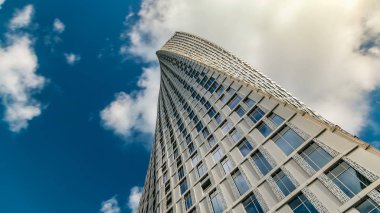 Dubai Yat Limanı içinde Cayan kule timelapse (sonsuzluk Kulesi olarak da bilinir). Alt perspektif görünümden bulutlu mavi gökyüzü için kule bir bükülme ile 90 derece - 306 metre ile bina dünyanın en yüksek yüksek artıyor
