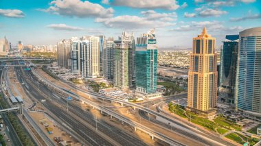 Dubai marina gökdelenlerinin ve Jumeirah göl kulelerinin hava görüntüsü Şeyh zayed yolundaki trafiği gösteriyor. Bulutlu mavi gökyüzü ile gün batımı zamanı