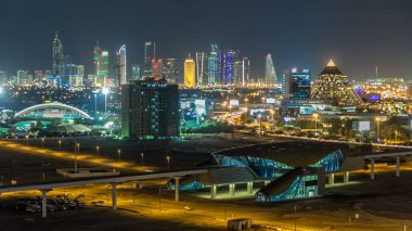 Geceleri doğal Dubai şehir manzarası timelapse. Şeyh Zayed Caddesi üzerinde çok sayıda ışıklı kuleleri, gökdelenler ve metro istasyonu ile en iyi görünümü. Yolda trafik. Ünlü dönüm noktası