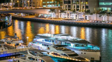 Dubai Yat Limanı vew yatların kuleleri ve yakın restoran alışveriş merkezinde Dubai gece timelapse, Birleşik Arap Emirlikleri arasında köprü. Dubai Yat Limanı Dubai ve bir yapay canal city kuzeyinde. 