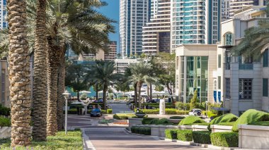 Arka plan, gün süre içinde modern kuleli Marina yürüyüşte, Çeşme ve avuç içi timelapse. Dubai, Birleşik Arap Emirlikleri