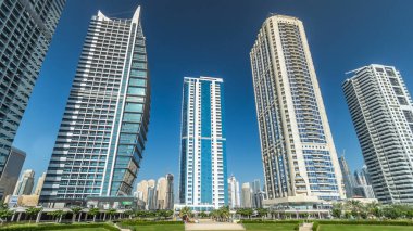 Gökdelenler, avuç içi ile waterfront Timelapse hyperlapse görünümü. Jumeirah Gölü Towers cam Dubai, BAE park civarındaki konut kaplı. Jlt 79 kuleleri 3 yapay göl ve park ile oluşan büyük bir gelişmedir.