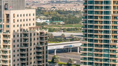 Golf alan ve Dubai siluetinin timelapse Şeyh zayed yolu üzerinde trafik ile gün anda yukarıdan. Yeşil çimen golf sahası arka planı, günbatımında şehir gökdelenler. Yanında modern kuleleri