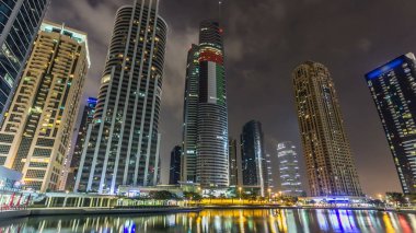 Gökdelenler, avuç içi ile waterfront Timelapse hyperlapse gece görünümü. Konut Jumeirah Gölü kulelerinde Dubai, Birleşik Arap Emirlikleri. Jlt 79 kuleleri 3 yapay göl ve park ile oluşan büyük bir gelişmedir. Set görüntülemek