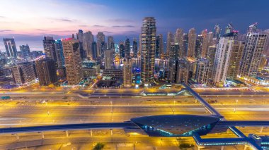 Dubai, Birleşik Arap Emirlikleri Dubai Yat Limanı ve Jlt gökdelenlerin gece geçiş timelapse güzel hava üstten görünüm günler. Modern kuleleri ve metro ve tramvay istasyonu ile Şeyh zayed yolu üzerinde trafik