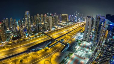 Dubai, Birleşik Arap Emirlikleri Dubai Yat Limanı ve Jlt gökdelenlerin gece timelapse güzel hava en iyi manzaraya. Yanıp sönen ışıklar ve metro hattı ve tramvay istasyonu ile yolda trafik ile ışıklı modern kuleleri. Balık gözü lens
