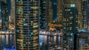 Dubai Yat Limanı mesire ve kanal kayan yat ve tekne Dubai, Birleşik Arap Emirlikleri ile gece timelapse güzel hava en iyi manzaraya. Yanıp sönen ışıklar ve yolda trafik ile ışıklı modern kuleleri. 