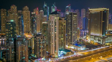 Dubai Yat Limanı mesire ve kanal kayan yat ve tekne Dubai, Birleşik Arap Emirlikleri ile gece timelapse güzel hava en iyi manzaraya. Yanıp sönen ışıklar ve yolda trafik ile ışıklı modern kuleleri. 